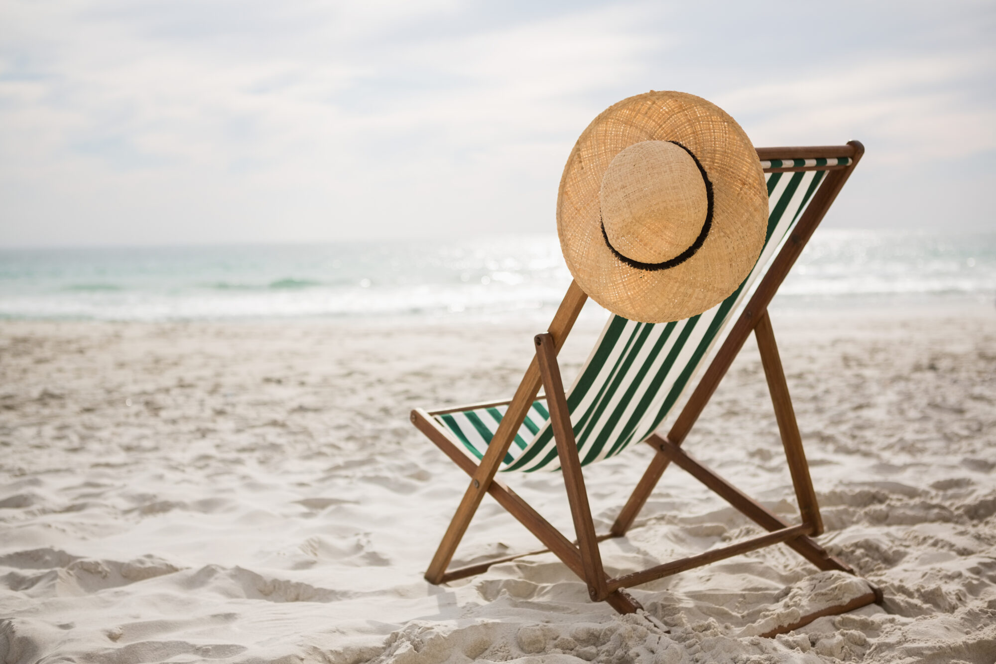 - Chronique radio : Les meilleures huiles essentielles pour l’été (moustiques, soleil, détente) - Straw hat kept on empty beach chair